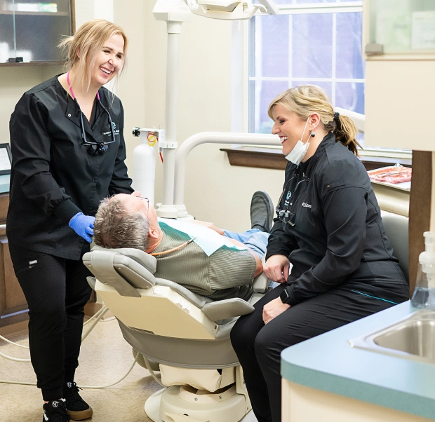 Dental team performing professional dental cleaning for patient in Bedford, TX office
