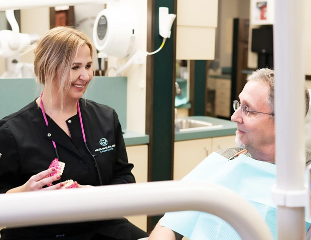 Dentist explaining fluoride treatment to patient in Bedford, TX dental office for cavity prevention and stronger enamel