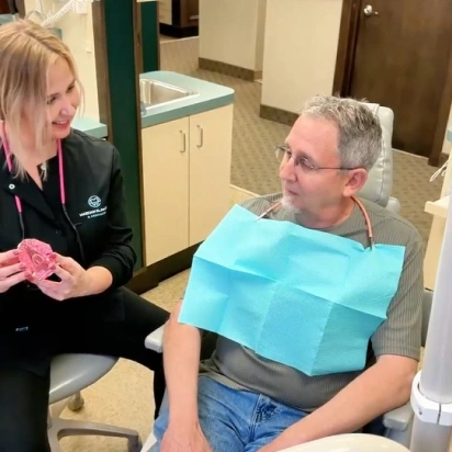 Dentist explaining dental procedure to patient, showcasing meticulous care at Bedford dental office